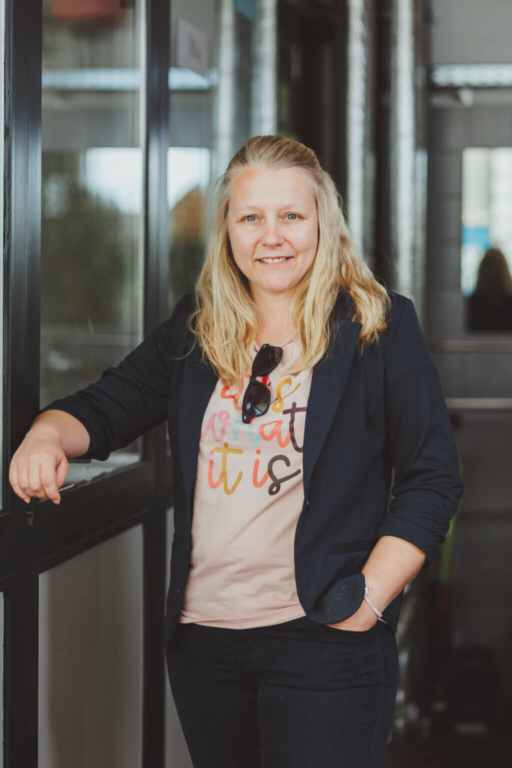Susann Schlatterer lehnt lächelnd an einer Glastür, SEO-Beraterin bei schlatterer.digital